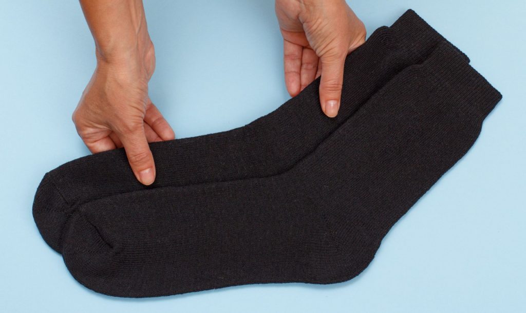 Thick socks held out by person